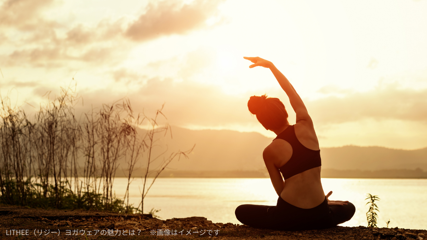夕暮れの湖畔でヨガポーズをとる女性のイメージ写真